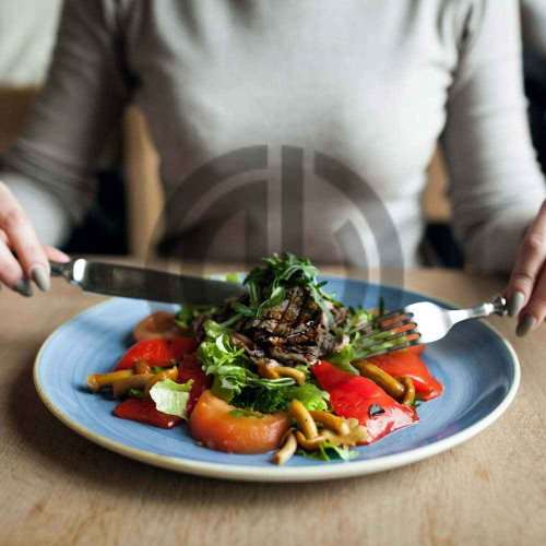saglikli beslenen kadin masada salata ve et yer